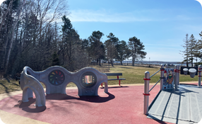 Outdoor playground under a blue sky with trees in the background
