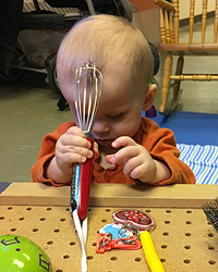 Preschooler exploring objects in a classroom