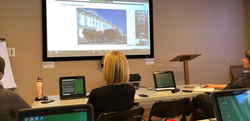 Staff in a classroom watching an online workshop