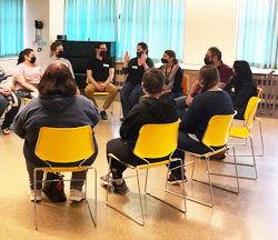 People sitting in chairs around a circle during a group session