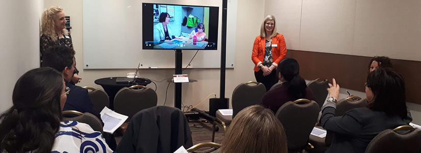 Staff presenting in a room at the conference with audience memeber asking a question