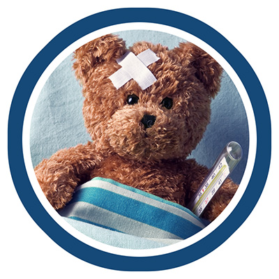 Teddy bear with a bandage on its head lies in bed, covered with a blue-striped blanket, holding a thermometer. The mood is caring and nurturing.